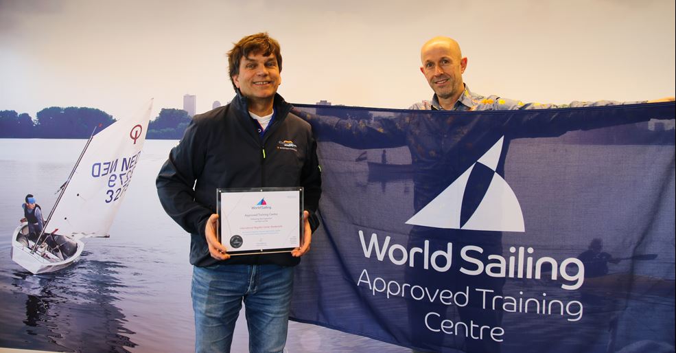 Op de foto: Watersportacademy-stafleden Bart van Breemen en Christoffel van Hees met het certificaat van World Sailing en bijbehorende erkenningsvlag.