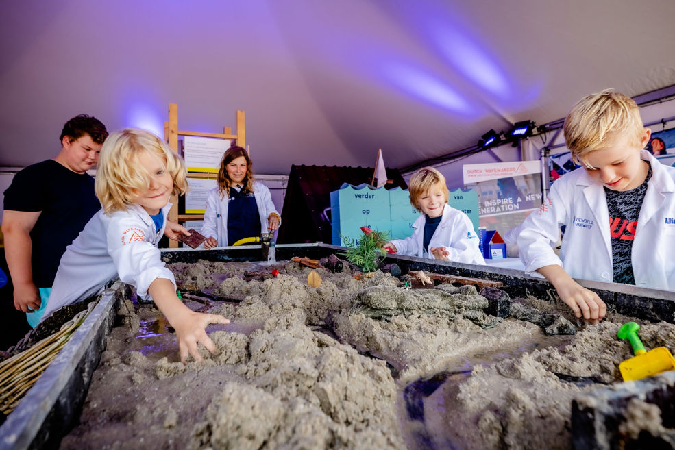 Kinderen bedwingen het stromende water bij het waterlaboratorium