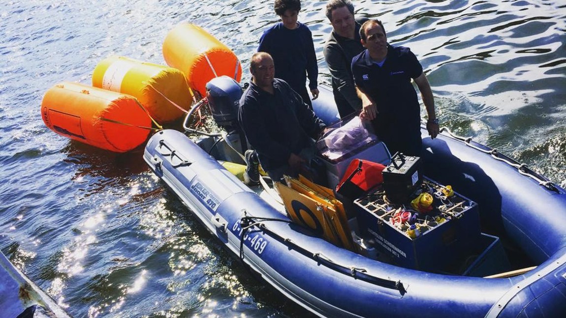 Tim de held rechts voorin de boot samen met een deel van het wedstrijdcomité.