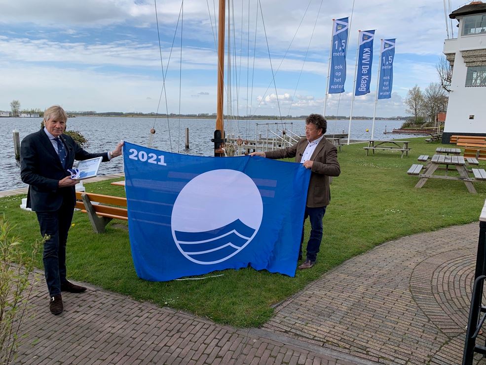 Rob Brinkel (l), bestuurslid Havens en Opstallen KWV de Kaag, ontvangt de Blauwe vlag van Erik van Dijk, directeur Stichting de Blauwe Vlag.